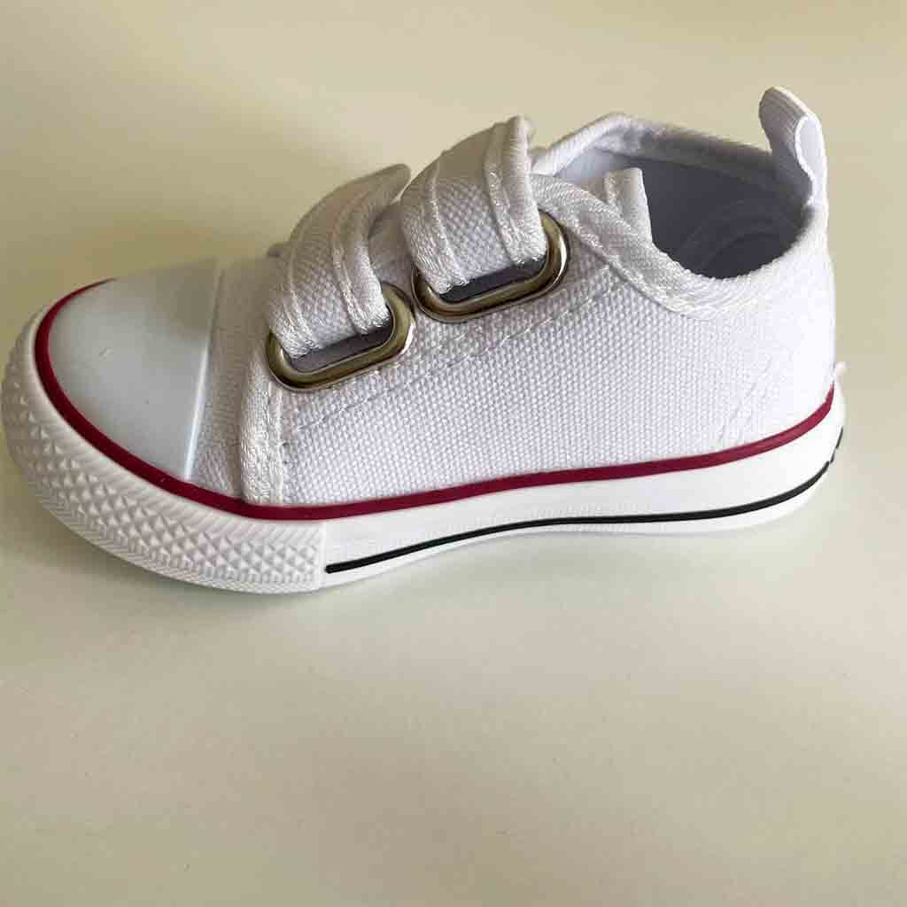 Detalle lateral de zapatillas de lona con velcro para bebé niño o niña. Marca Bubble Bobble. Color blanco.