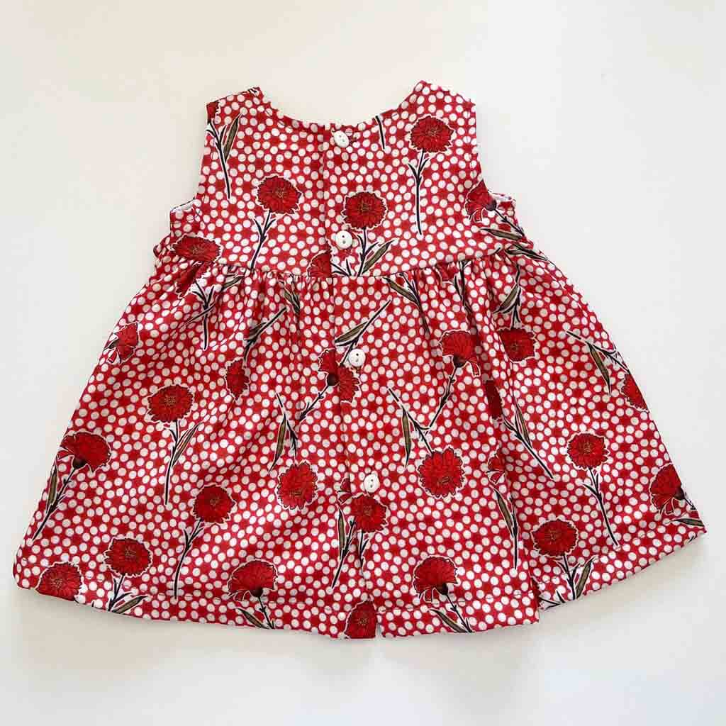 Detalle parte trasera abotonada de vestido para bebé niña en rojo y blanco. Primavera-Verano. Marca Confecciones Alber.