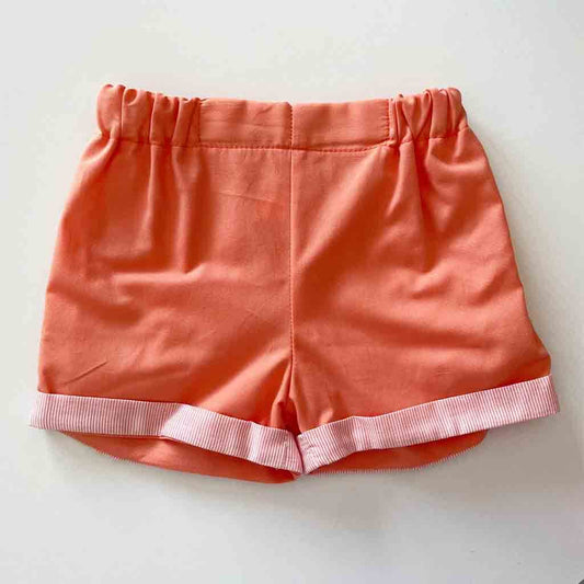 Detalle pantalón corto de conjunto casual para bebé niño. Primavera-Verano. Dos piezas. Marca Confecciones Alber. Color naranja con rajas blancas.