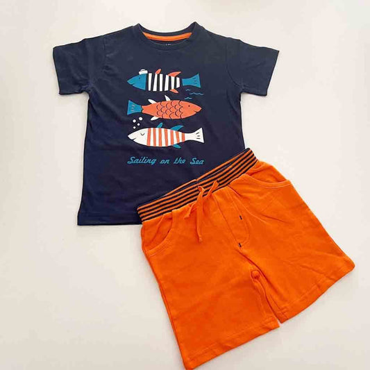 Comprar conjunto de algodón divertido para niños de hasta 6 años de edad. Primavera-Verano. Dos piezas; camiseta y pantalón corto. Marca Babybol. Color azul marino con estampado de peces y pantalón naranja.