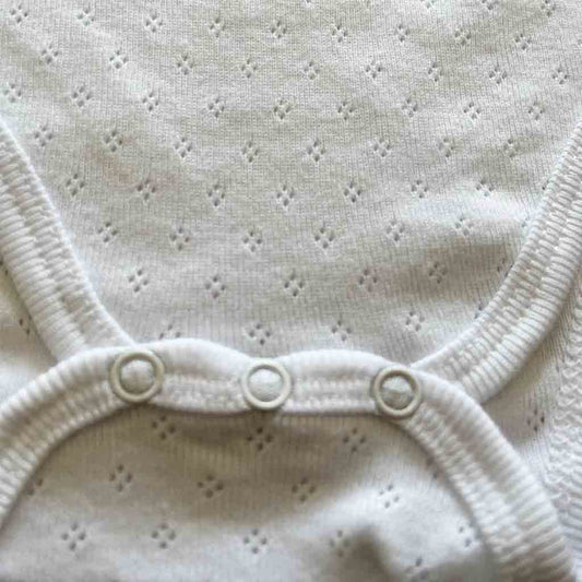 Detalle cierre de body de algodón para recién nacido niño y niña. Manga corta. Primavera-Verano. Marca Armony Baby Boutique. Color blanco.