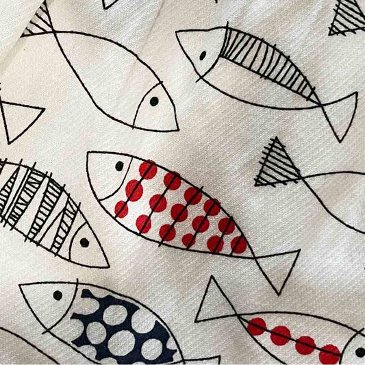 Detalle del estampado de vestido para bebé niña. Primavera-Verano. Marca Newness. Color blanco con estampado de peces.