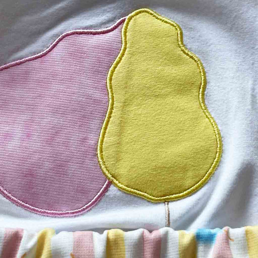 Detalle de algodón de azúcar de conjunto divertido para bebé niña. Dos piezas; falda y camiseta. Primavera-Verano. Marca Petit Cle. Color blanco y multicolor.