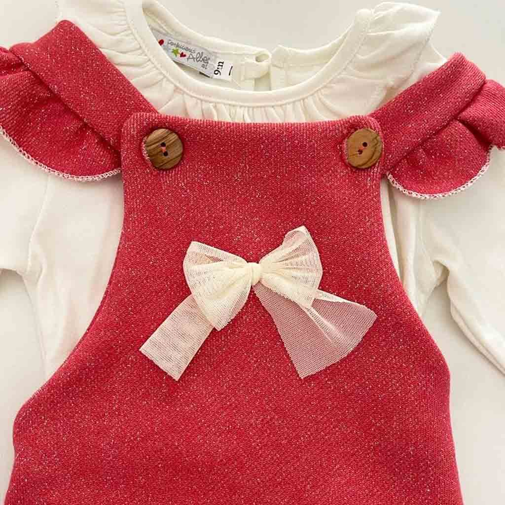 Detalle de moña de peto para bebé niña de dos piezas. Color rosa fresa y blanco crudo.