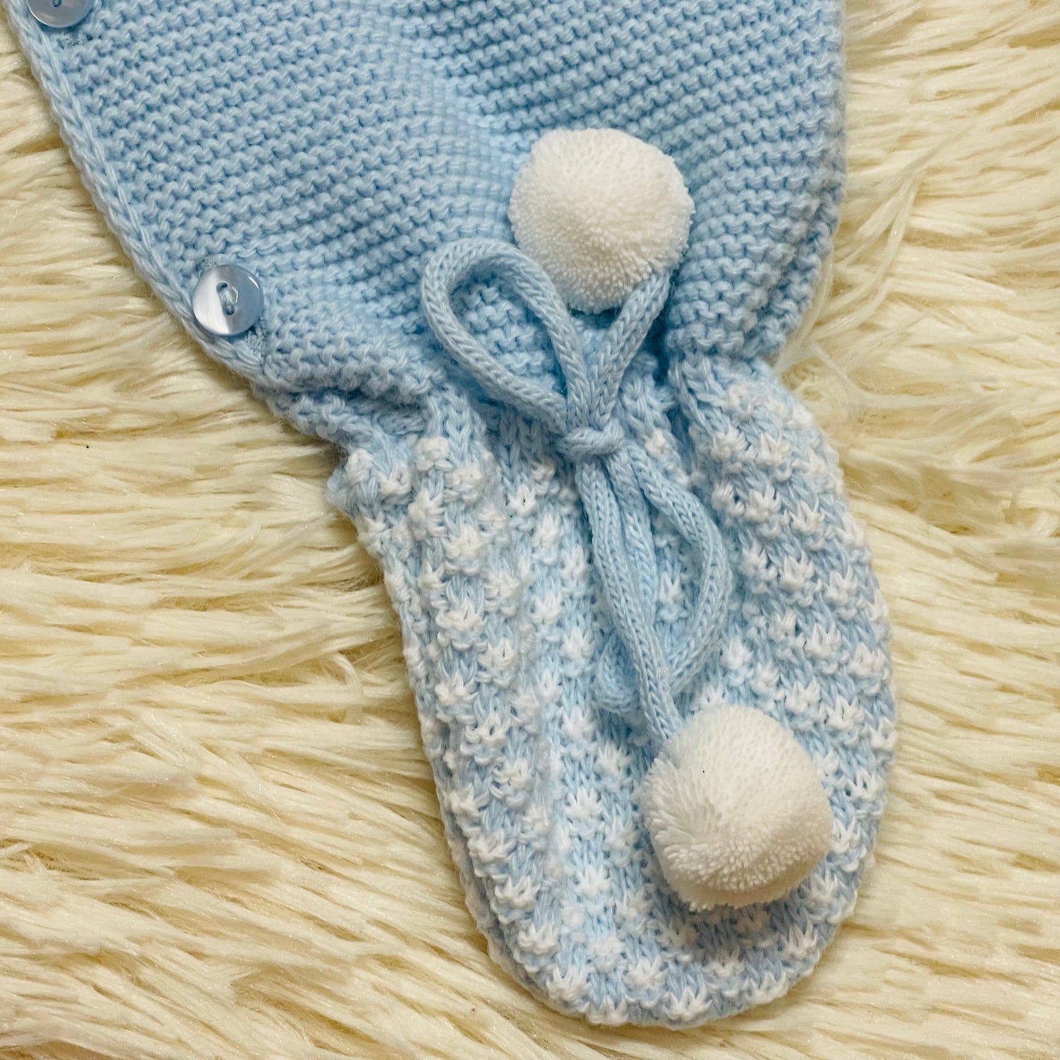 Comprar conjunto de lana para bebés recién nacidos. Detalle de borlas en los pies. Color celeste. Temporada otoño/invierno.